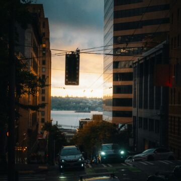 josh-hild-LuKMcTmGW_k-unsplash City street overlooking water at sunset, symbolising an urban weekend getaway.