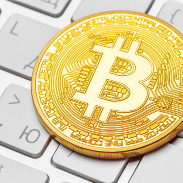 Close-up of a physical bitcoin on keyboard Close-up of a physical bitcoin on keyboard