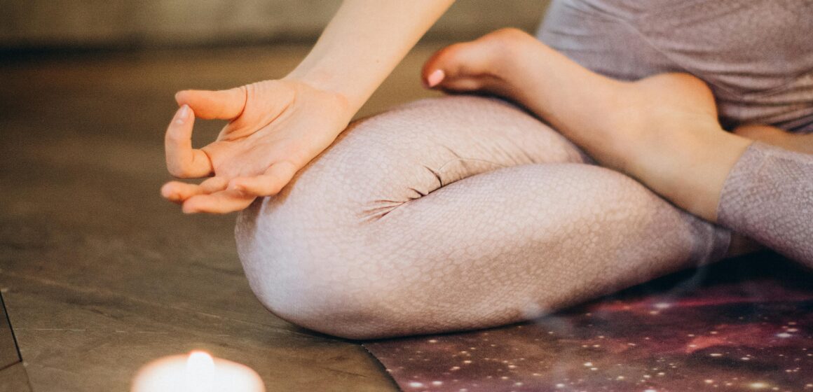 Person writing in a journal at sunrise overlooking a city, symbolizing Stoic self discipline